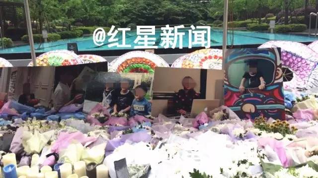 事发小区内，祭奠死者朱女士和三个孩子的花圈、鲜花、照片摆放在一起 受访者供图