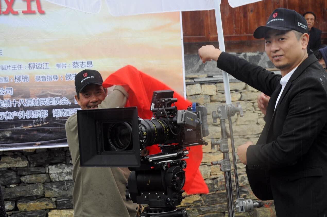 图七:演员周光大与电影总制片人成功共同揭开摄像机红布电影《爱在